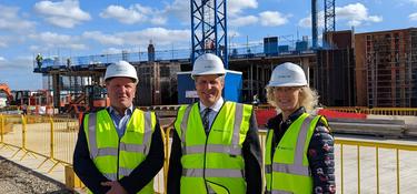 Three Prologis UK team members stand in front of a construction site