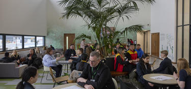 Group of adults sat at tables in communal area of The Hub at Prologis DIRFT