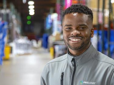 A man in a Prologis jacket smiling at the camera in a warehouse