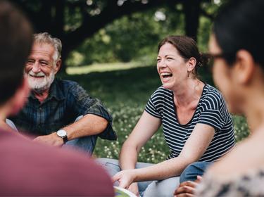 Four people in a circle, talking and laughing