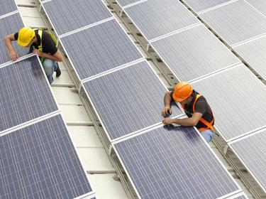 Two men working on repairing solar panels