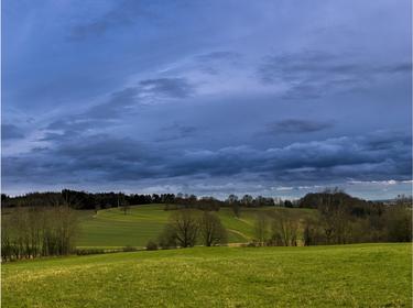 A landscape view of the countryside with a dark sky