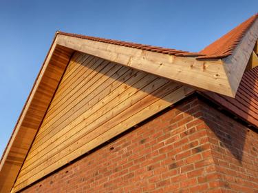 A angled roof of a wooden building showing the peak