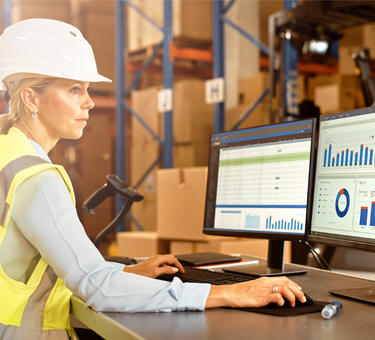 A woman in a warehouse working with fleet management software